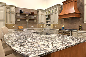 Gray kitchen cabinetry with marble countertops